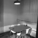 Besprechungsraum im DGTL.ONE Büro mit Tisch, weißen Stühlen und Hängelampe