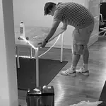 Kollege beim Anbringen einer Lichtleiste am Schreibtisch im Büro