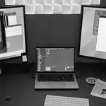 Arbeitsplatz mit Laptop, zwei Monitoren und Lichtpaneelen